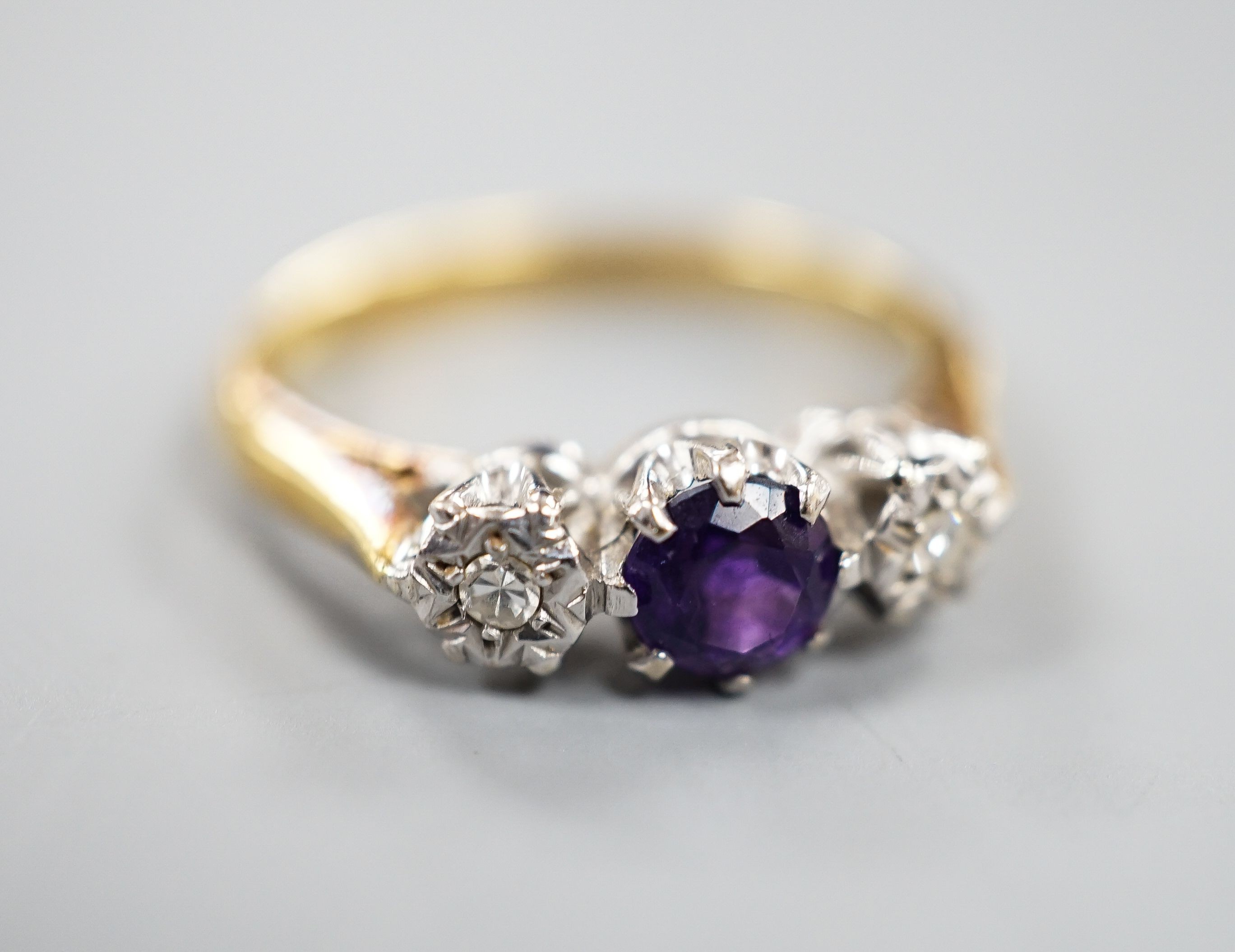An 18ct, singe stone amethyst and illusion set two stone diamond ring, size, O/P, gross weight 3.7 grams.